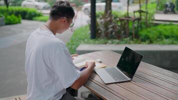 A man sitting at a table with a laptop video