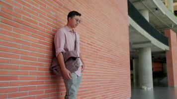 A man leaning against a brick wall video