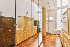 A bedroom with a large mirror and wooden flooring photo