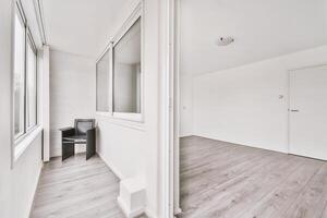 An empty room with a chair and a window photo