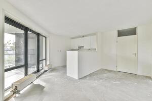 An empty room with a large window and a white wall photo