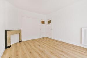 An empty room with a fireplace and wooden floors photo