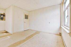 An empty room with a window and a door photo