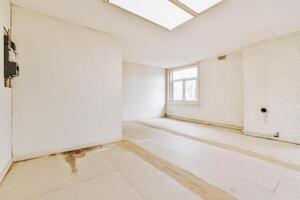 A white room with a skylight and a window photo