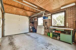 A garage with a large open door and a work bench photo