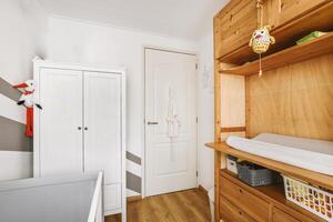 A small baby room with a wooden cabinet and a changing table photo