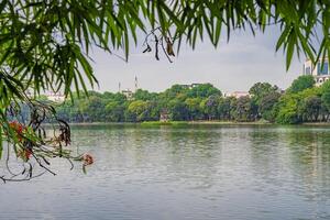 Hanoi, Vietnam - 26 June 2024 Hoan Kiem lake or Sword lake, Ho Guom in Hanoi, Vietnam with Turtle Tower, on clear day with blue sky and white clouds photo