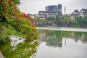 Hanoi, Vietnam - 26 June 2024 Hoan Kiem lake or Sword lake, Ho Guom in Hanoi, Vietnam with Turtle Tower, on clear day with blue sky and white clouds photo