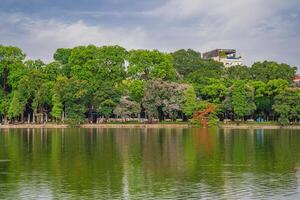 Hanoi, Vietnam - 26 June 2024 Hoan Kiem lake or Sword lake, Ho Guom in Hanoi, Vietnam with Turtle Tower, on clear day with blue sky and white clouds photo