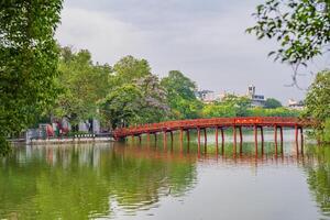 Hanoi, Vietnam - 26 June 2024 Red The Huc Bridge and Ngoc Son Temple in the center of Hoan Kiem Lake, Hanoi, Vietnam. Famous destination of Vietnam photo