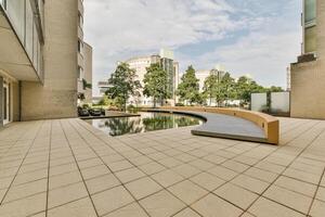 A patio with a fountain and benches in front of a building photo