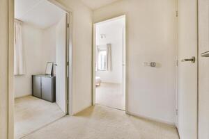 A hallway with a door and a cabinet photo