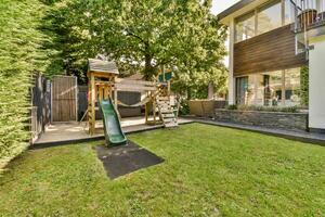 A backyard with a swing set and a tree photo