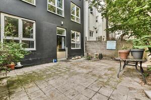 A patio with a table and chairs in front of a house photo