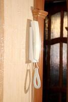 The intercom handset hangs on the wall - view of the device in profile photo