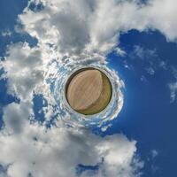 simple little tiny planet without buildings in blue sky with beautiful clouds. Transformation of spherical panorama 360 degrees. Spherical abstract aerial view. Curvature of space. photo