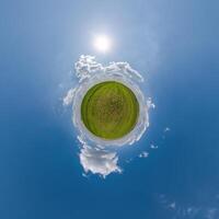 simple little tiny planet without buildings in blue sky with beautiful clouds. Transformation of spherical panorama 360 degrees. Spherical abstract aerial view. Curvature of space. photo