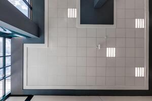 cassette stretched or suspended ceiling with square halogen spots lamps and drywall construction in empty room in house or office. Looking up view photo