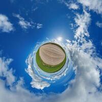 simple little tiny planet without buildings in blue sky with beautiful clouds. Transformation of spherical panorama 360 degrees. Spherical abstract aerial view. Curvature of space. photo