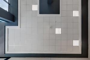 cassette stretched or suspended ceiling with square halogen spots lamps and drywall construction in empty room in house or office. Looking up view photo