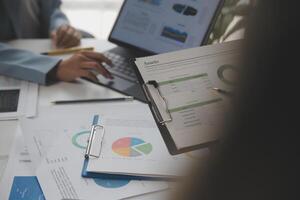 Close up of Business team analyzing income charts and graphs with modern laptop computer. Business analysis and strategy concept. photo