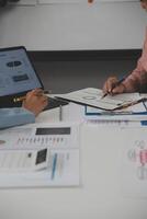 Close up of Business team analyzing income charts and graphs with modern laptop computer. Business analysis and strategy concept. photo