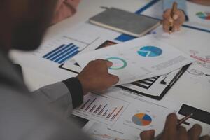 Close up of Business team analyzing income charts and graphs with modern laptop computer. Business analysis and strategy concept. photo
