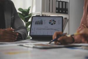 Close up of Business team analyzing income charts and graphs with modern laptop computer. Business analysis and strategy concept. photo