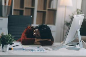 The business lady and the employee take a nap while working on the office desk. Working women are exhausted and sleeping on the table photo