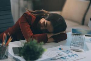 The business lady and the employee take a nap while working on the office desk. Working women are exhausted and sleeping on the table photo