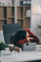 The business lady and the employee take a nap while working on the office desk. Working women are exhausted and sleeping on the table photo