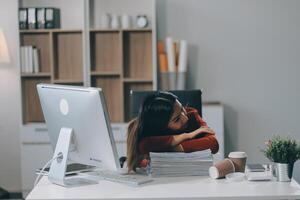 The business lady and the employee take a nap while working on the office desk. Working women are exhausted and sleeping on the table photo