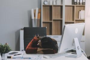 The business lady and the employee take a nap while working on the office desk. Working women are exhausted and sleeping on the table photo