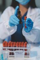 Group of dedicated scientist conduct chemical experiment in medical laboratory, carefully drop precise amount of liquid from pipette into test tube for vaccine drug or antibiotic development. Neoteric photo