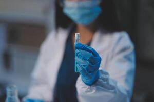 Group of dedicated scientist conduct chemical experiment in medical laboratory, carefully drop precise amount of liquid from pipette into test tube for vaccine drug or antibiotic development. Neoteric photo