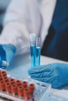 Group of dedicated scientist conduct chemical experiment in medical laboratory, carefully drop precise amount of liquid from pipette into test tube for vaccine drug or antibiotic development. Neoteric photo