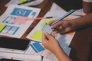 The designer team is designing the uxui system to make the uxui system work well on new phones and support system updates. Website development concept UI UX front end designer photo