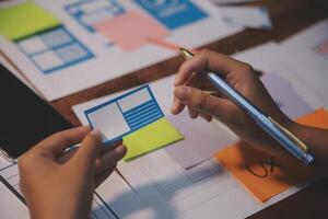 The designer team is designing the uxui system to make the uxui system work well on new phones and support system updates. Website development concept UI UX front end designer photo
