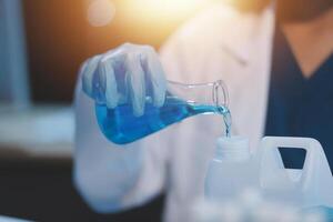 Group of dedicated scientist conduct chemical experiment in medical laboratory, carefully drop precise amount of liquid from pipette into test tube for vaccine drug or antibiotic development. Neoteric photo