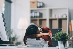 The business lady and the employee take a nap while working on the office desk. Working women are exhausted and sleeping on the table photo