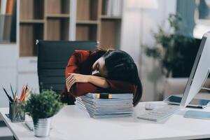 The business lady and the employee take a nap while working on the office desk. Working women are exhausted and sleeping on the table photo