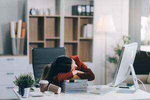 The business lady and the employee take a nap while working on the office desk. Working women are exhausted and sleeping on the table photo