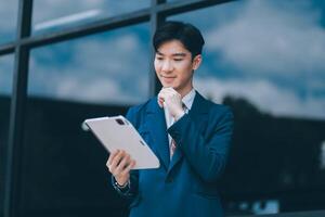 Businessman using tablet and enjoying in coffee break in front of the the corporation. Business, lifestyle concept photo