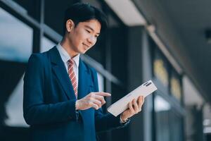 Businessman using tablet and enjoying in coffee break in front of the the corporation. Business, lifestyle concept photo