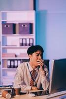 Businessman workaholic sit at the computer working late at night yawn tired and sleeping in the office,Hard work in the later time concept photo