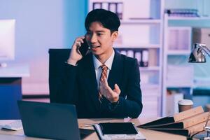 Serious trader using mobile phone app on smartphone for checking stock trading data analysis concept, focused businessman holding cellphone working in office with financial graph on computer monitors photo