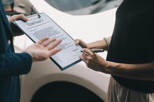 A young businesswoman is navigating car insurance options at her desk, considering premiums, deductibles, and coverage while understanding policies and managing claims efficiently. photo