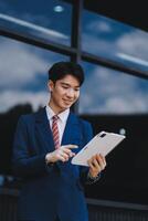 Businessman using tablet and enjoying in coffee break in front of the the corporation. Business, lifestyle concept photo