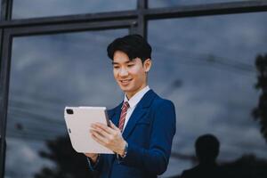 Businessman using tablet and enjoying in coffee break in front of the the corporation. Business, lifestyle concept photo