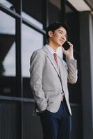 Good news about project. Young businessman talking with client via mobile phone and checking money transfer on tablet. Business, education, lifestyle concept photo